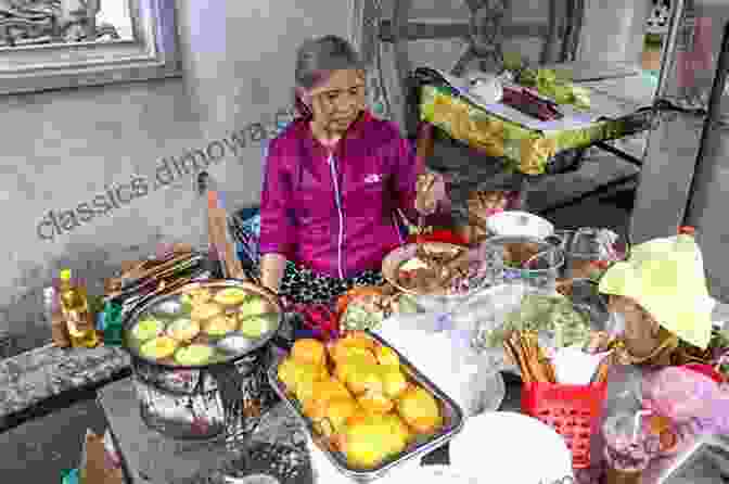 A Photo Of A Street Vendor In Vietnam, Cooking Up A Delicious Dish VIETNAMESE TRAVEL GUIDE: Welcom To VietNam